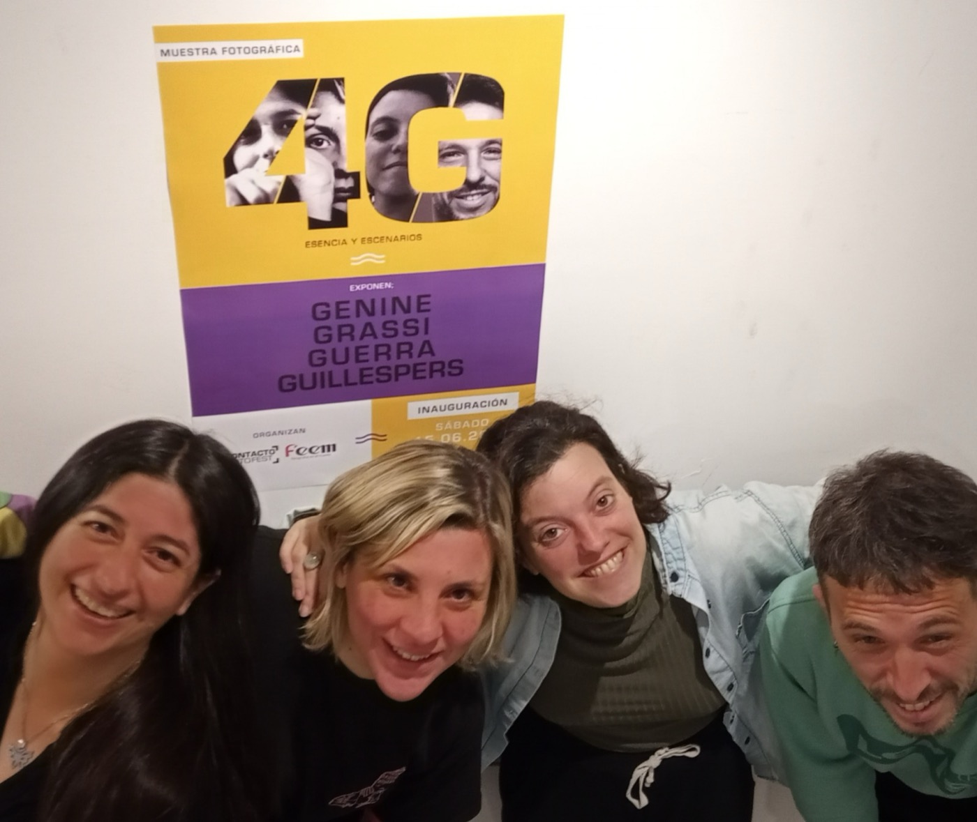 Las autoras y el autor de 4G en la inauguración, bajo el afiche de la muestra
